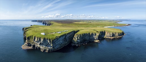 Aerial panorama of the rugged coastal landscape at Duncansby Head with the lighthouse, behind it