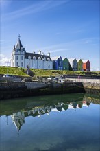 Holiday homes reflected in the ferry harbour of John o' Groats, County Caithness, Scotland, United