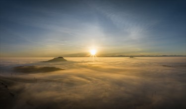 Aerial panorama of the wintry and fog-covered Hegaulandschaft at sunrise, on the left on the