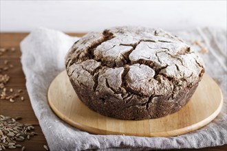 Yeast free homemade bread with whole rye and wheat grains on rustic wooden background. close up