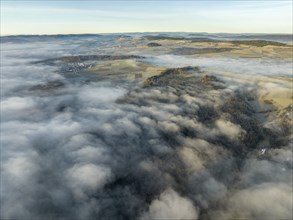 Aerial view of the wintry and fog-covered Hegaulandschaft shortly after sunrise, on the horizon the