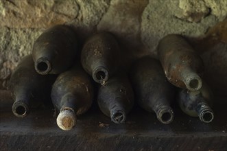 Old empty wine bottles standing abandoned on a shelf. Bas-Rhin, Collectivite europeenne d'Alsace,