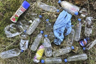 Discarded plastic bottles and other non-degradable rubbish in field