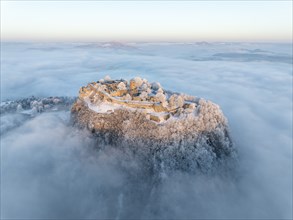 Aerial view of the Hegau volcano Hohentwiel with Germany's largest fortress ruins on a cold, foggy