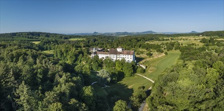 Aerial panorama of Langenstein Castle near Eigeltingen with surrounding golf course, on the horizon