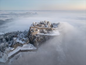 Aerial view of the Hegau volcano Hohentwiel with Germany's largest fortress ruins on a cold, foggy