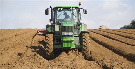 Farm machinery preparing and planting a crop of potatoes in a field, Shottisham, Suffolk, England,