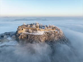 Aerial view of the Hegau volcano Hohentwiel with Germany's largest fortress ruins on a cold, foggy