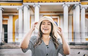 Portrait of a tourist girl with hat in a tourist square. Granada, Nicaragua. Portrait of smiling