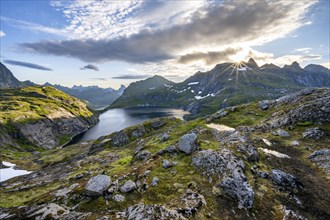 Mountain landscape with lake Tennesvatnet, at sunrise with sun star, Moskenesoya, Lofoten,