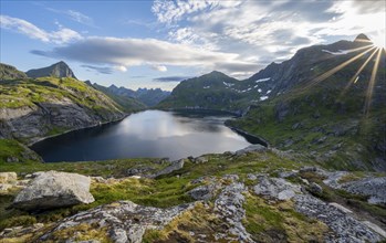 Mountain landscape with lake Tennesvatnet, at sunrise with sun star, Moskenesoya, Lofoten,