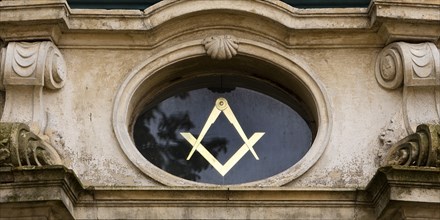 Close-up with compass and angle, two of the best-known symbols of Freemasonry on the lodge house,