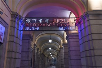 Nocturnal illuminated advertising in the historic arcade at the harbour, Genoa, Italy, Europe