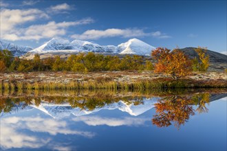 Reflection of the autumn landscape in Rondane National Park, snow-capped mountains, Doraldalen,