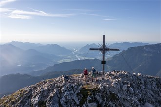 Two hikers at the summit, aerial view, evening mood in the mountains, summit cross of the