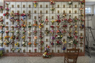 Urn graves with floral decorations in a hall at the Monumental Cemetery, Cimitero monumentale di