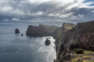 Red cliffs and rocks in the sea, coastal landscape with dramatic sky, Ponta de Sao Lourenço,