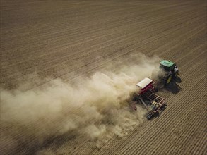 A tractor with a Horsch PRONTO DC 6 seed drill sowing in a dry field in late summer., Doma, Saxony,