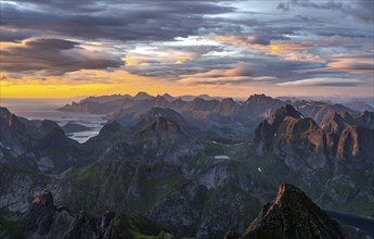 View over mountain top and sea, dramatic sunset, from the top of Hermannsdalstinden, Moskenesöy,