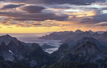 View over mountain top and sea to Fredvang, dramatic sunset, from the top of Hermannsdalstinden,