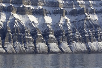 Snow covered Carboniferous mountain slope showing strata in autumn, Billefjord, Billefjorden,