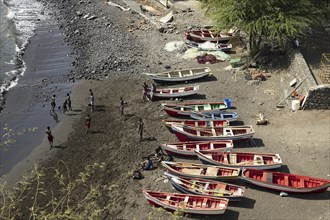 Youth playing soccer on the beach in front of traditional wooden fishing boats, Cidade Velha on the