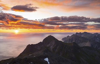 View over mountain top and sea, dramatic sunset, from the top of Hermannsdalstinden, Moskenesöy,