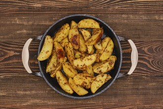 Potato wedges roasted in oven with thyme and salt, top view