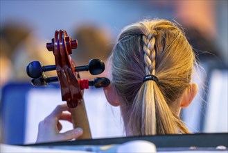 Young girl plays a cello at a concert