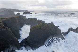 Large Atlantic storm waves crashing onto jagged rocky coast at Hartland Quay, north Devon, England,