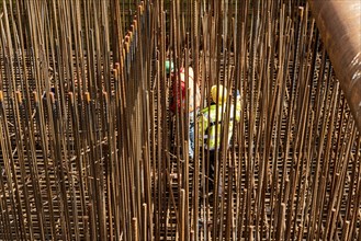 Construction site, reinforced concrete construction site, workers erect a mesh of reinforcing bars,