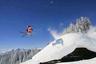 Skier in action, man, 35, 40, years, jumps over a hut covered with snow