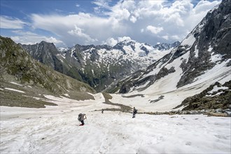 Mountaineers hiking in a snowfield, Nördliche Mörchnerscharte, behind mountain peak Kleiner