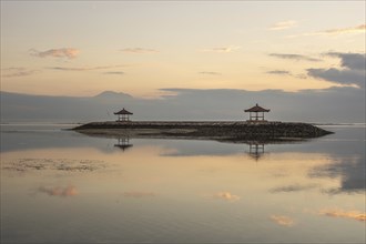 Beautiful seascape in the morning. Tropical sandy beach with breakwater and reflection of the sky