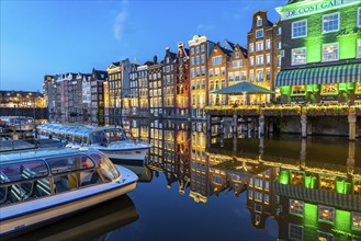 Canal houses on the Damrak, in the centre of the old town of Amsterdam, harbour, starting point of