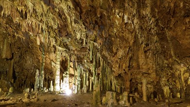 Wide cave hall with illuminated stalactites and stalagmites, stalactite cave, Diros Cave, Glyafada