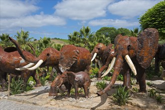 Group of metal sculptures depicting elephants in a park with trees under a blue sky, Bacalhôa,