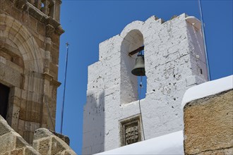 A striking bell tower made of white stones under a bright blue sky in Mediterranean architecture,