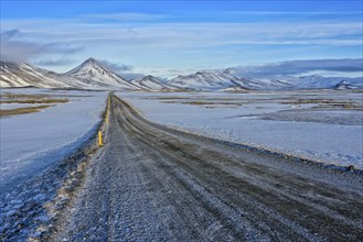 Ringroad no. 1 near farm Mödrudalur, gravel road, snowcovered mountain range between lake Myvatn