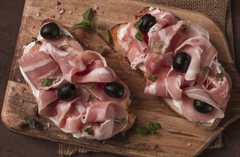 Breakfast, bacon and olives sandwich, on a cutting board, top view, close-up, no people