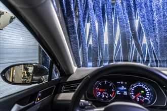 Car in an automatic car wash, car wash tunnel, drying, with hot air and rotating textile cloths