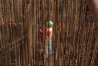 Construction site, reinforced concrete construction site, workers erect a mesh of reinforcing bars,