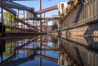 Zollverein coking plant, coke ovens, chimneys and conveyor bridges are reflected in the water