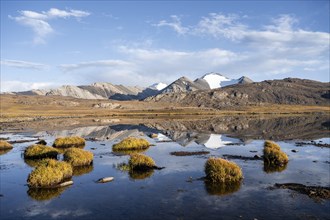 Glaciated mountain peaks reflected in a mountain lake at sunset, Arabel Lake at Arabel Pass, Issyk