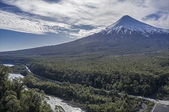 Snow-capped volcano Osorno rising high above river Rio Petrohue, early spring, chilenean lake