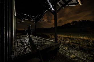 Old railway station at night with waiting person, Gessertshausen, Swabia, Bavaria, Germany, Europe