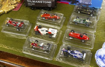 Boxed model racing cars in clear plastic boxes on display in auction room, UK