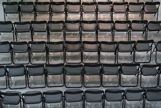 Folding chairs, at an event, still unused, in a row