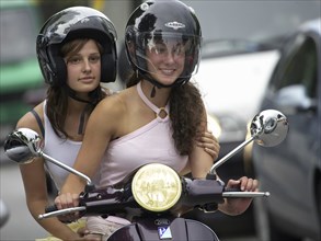 Two woman riding a scooter, Barcelona, Spaina