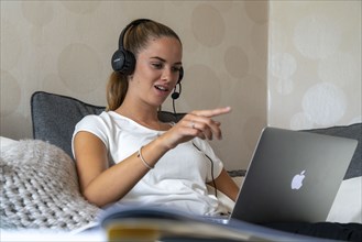 Young student learns at home, online, in conversation with other students